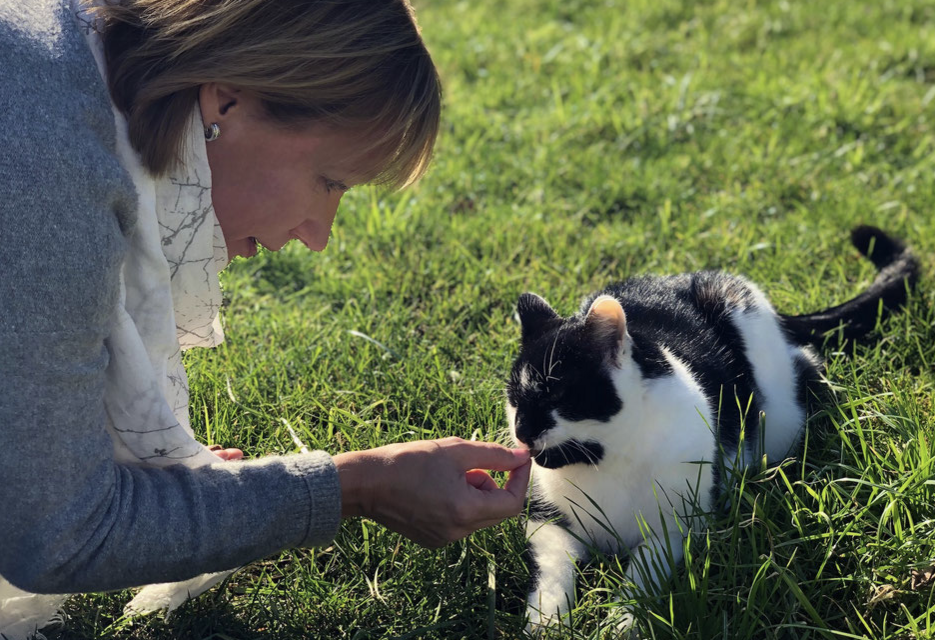 Ein Bild von Kerstin Huse mit einer schwarz-weißen Katze.